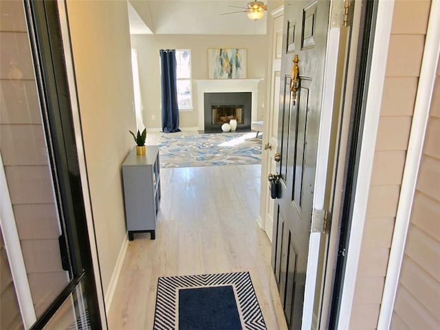 hallway featuring light wood-style flooring and baseboards