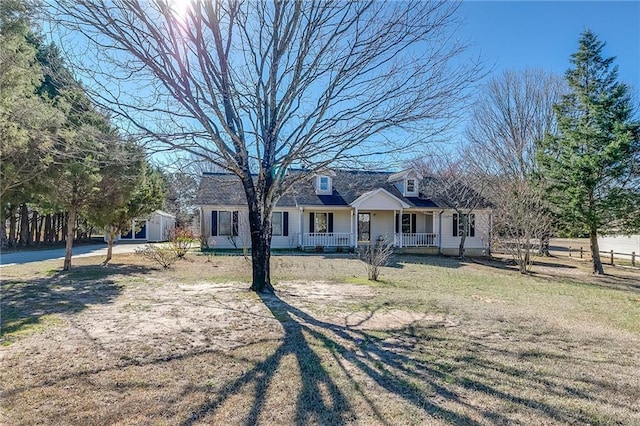 new england style home with a porch and a front lawn