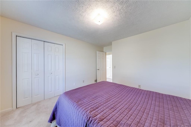 bedroom with a textured ceiling, a closet, and carpet