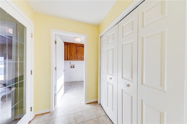 corridor with light tile patterned floors and baseboards