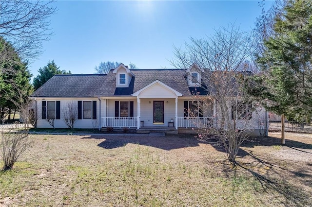 new england style home featuring covered porch and roof with shingles