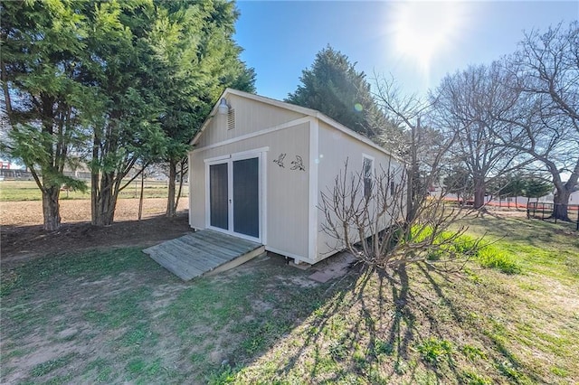 view of outdoor structure featuring an outbuilding and fence