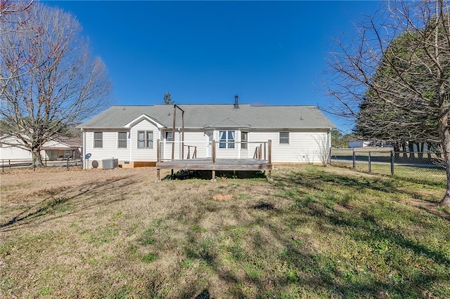 back of property featuring fence, a deck, cooling unit, and a yard