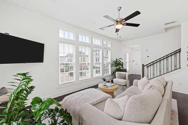 living room with dark wood-type flooring, ceiling fan, and plenty of natural light