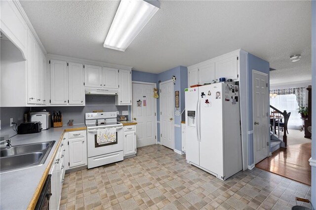 kitchen with white appliances, white cabinets, sink, light hardwood / wood-style flooring, and a textured ceiling