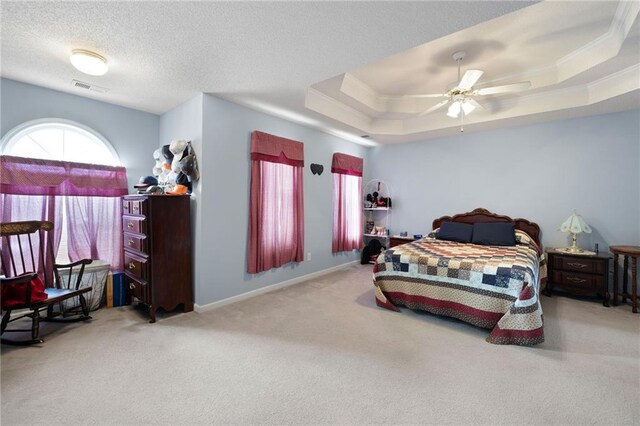 bedroom with ceiling fan, a raised ceiling, carpet floors, and ornamental molding