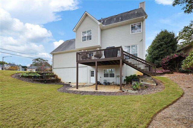 rear view of house with a lawn and a wooden deck