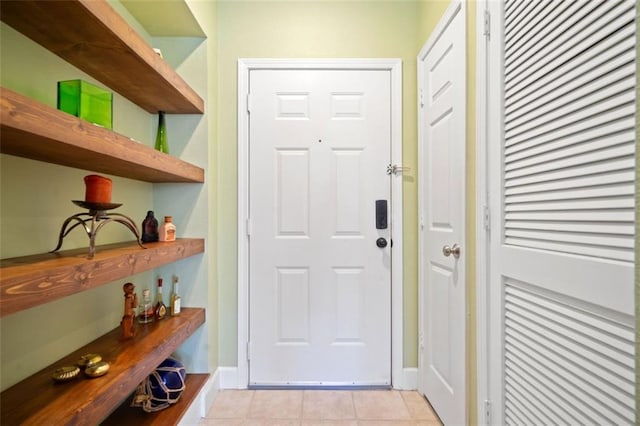 entryway with light tile patterned floors and baseboards