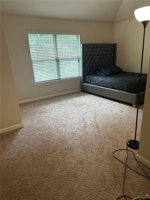 1749 Misselthrush Ln, Mcdonough, GA 30253 - bedroom featuring baseboards, carpet, and vaulted ceiling