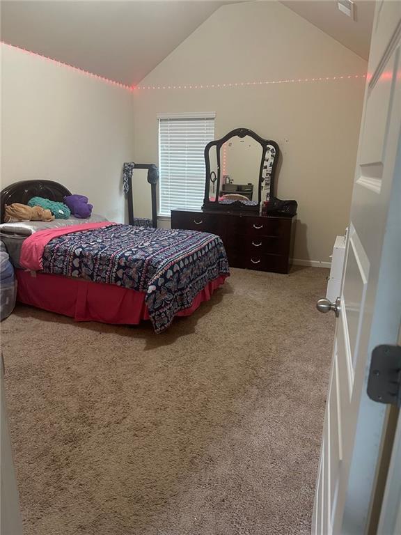 1749 Misselthrush Ln, Mcdonough, GA 30253 - bedroom with vaulted ceiling and carpet