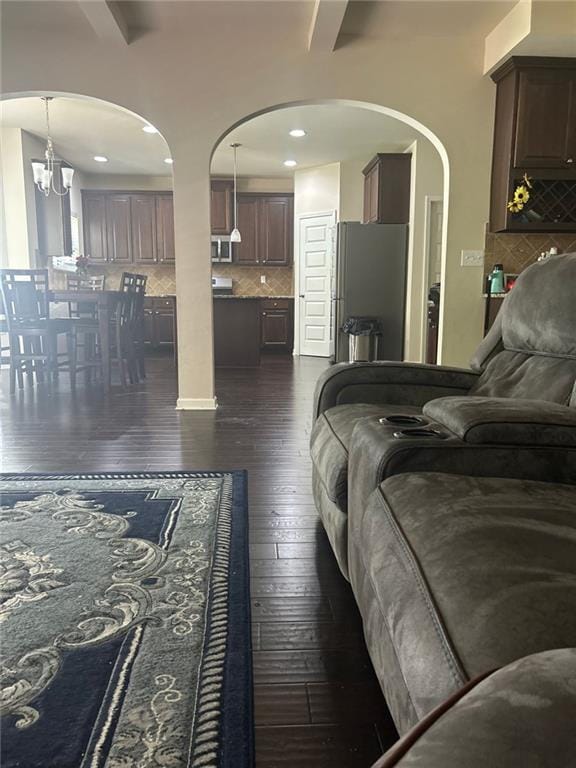 1749 Misselthrush Ln, Mcdonough, GA 30253 - bedroom with freestanding refrigerator, dark wood-style floors, arched walkways, recessed lighting, and a chandelier