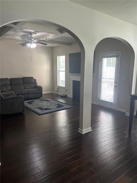1749 Misselthrush Ln, Mcdonough, GA 30253 - living area featuring coffered ceiling, a ceiling fan, dark wood-style flooring, plenty of natural light, and baseboards