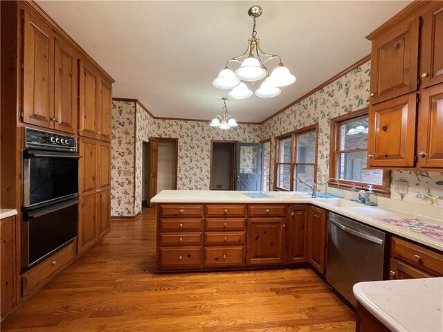 kitchen with dishwasher, light hardwood / wood-style floors, a chandelier, decorative light fixtures, and double oven