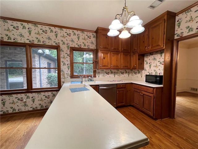 kitchen with dishwasher, decorative light fixtures, hardwood / wood-style flooring, ornamental molding, and a notable chandelier