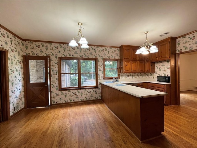 kitchen with pendant lighting, an inviting chandelier, and kitchen peninsula