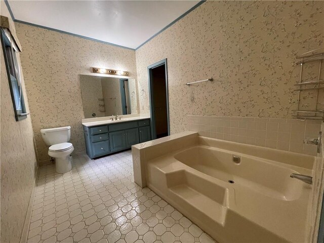 bathroom featuring a bath, crown molding, vanity, and toilet