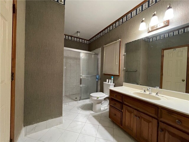 bathroom with vanity, tile patterned flooring, toilet, and a shower with door