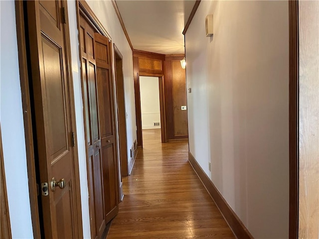 hallway with dark hardwood / wood-style floors and crown molding