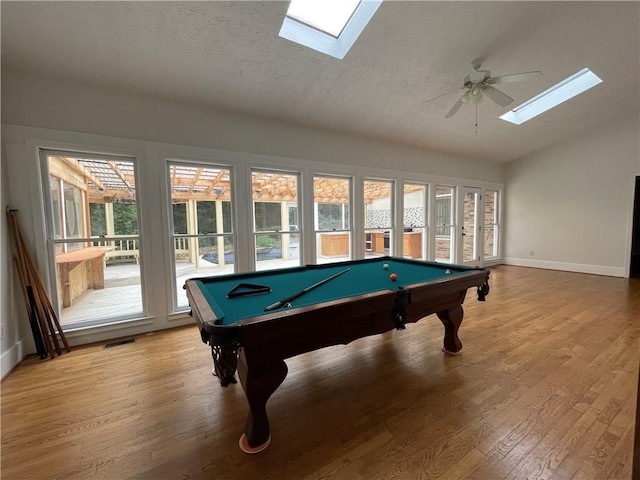 game room featuring lofted ceiling with skylight, a textured ceiling, hardwood / wood-style flooring, and billiards