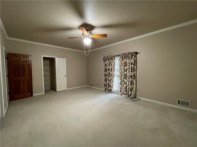 unfurnished bedroom featuring ceiling fan, light colored carpet, and crown molding