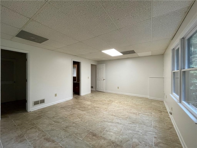 unfurnished room featuring a drop ceiling