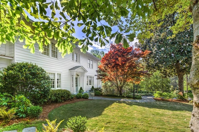 colonial inspired home featuring a front lawn