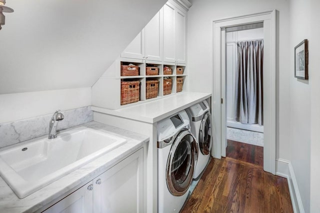 washroom featuring a sink, independent washer and dryer, cabinet space, and dark wood-style floors