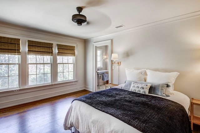 bedroom featuring crown molding, visible vents, baseboards, and wood finished floors