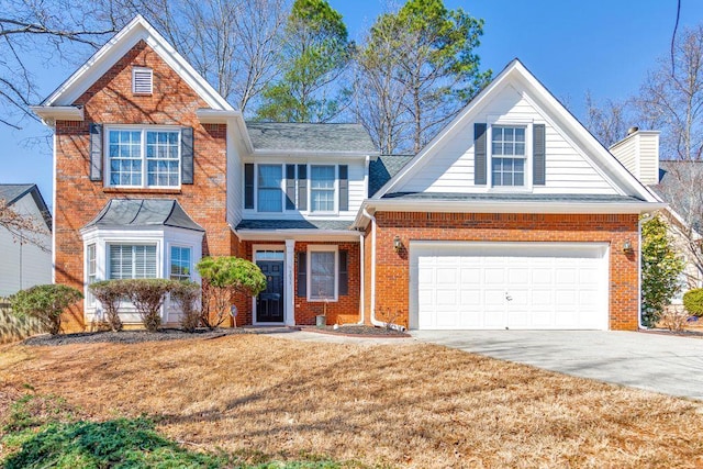 traditional home with a front yard, an attached garage, a chimney, concrete driveway, and brick siding