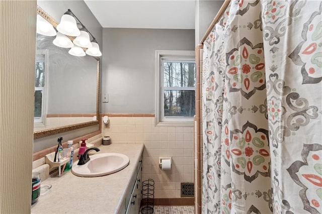 bathroom with vanity, curtained shower, and tile walls