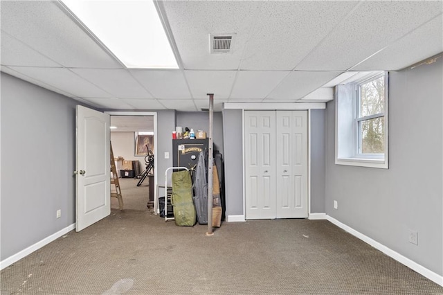 interior space with carpet floors and a drop ceiling