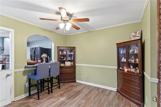 interior space featuring crown molding, light wood-type flooring, fridge, electric stove, and ceiling fan