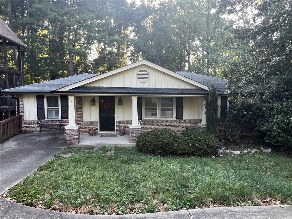 2713 Valvedere Dr NE, Atlanta, GA 30319 - view of front of home with brick siding, board and batten siding, a front lawn, and covered porch