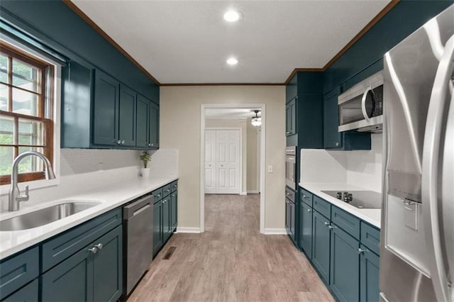 kitchen with ornamental molding, appliances with stainless steel finishes, light hardwood / wood-style flooring, and plenty of natural light