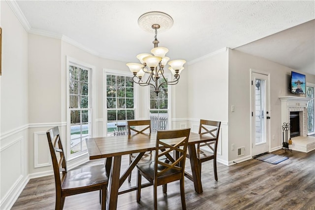 dining space with crown molding, a chandelier, and wood finished floors