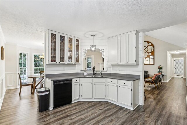 kitchen with a textured ceiling, dark countertops, a sink, white cabinets, and black dishwasher