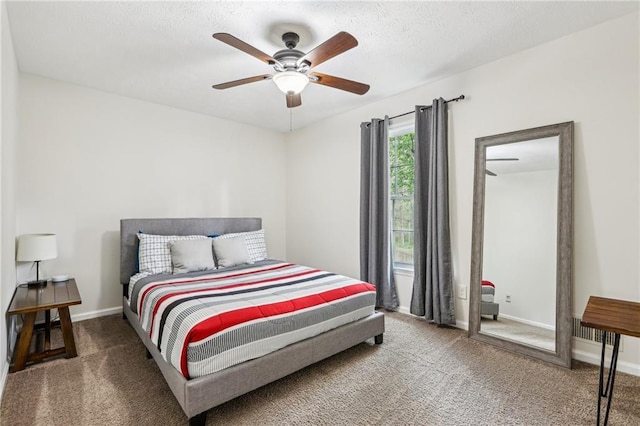 carpeted bedroom with baseboards, ceiling fan, and a textured ceiling
