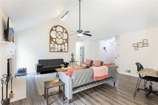 living room featuring visible vents, wood finished floors, baseboards, a ceiling fan, and vaulted ceiling