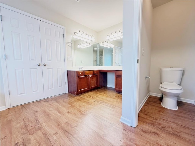 bathroom featuring wood-type flooring, vanity, and toilet