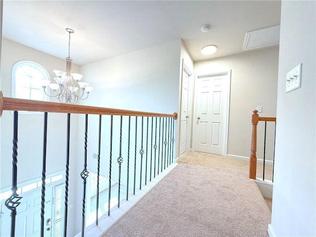 hallway with an inviting chandelier and carpet