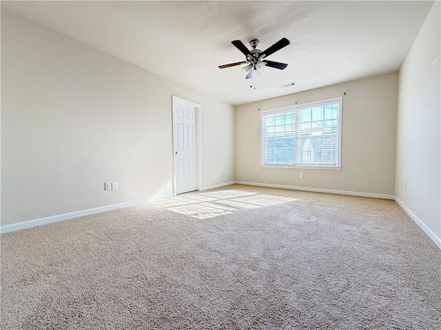 spare room with ceiling fan and light colored carpet