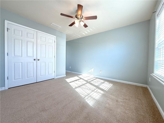 unfurnished bedroom with a closet, ceiling fan, and carpet flooring