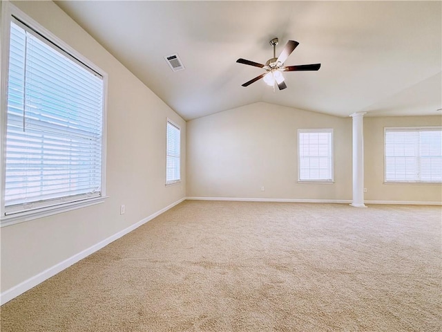 carpeted empty room with ornate columns, lofted ceiling, a healthy amount of sunlight, and ceiling fan