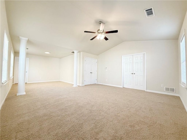 spare room with decorative columns, lofted ceiling, carpet floors, and ceiling fan