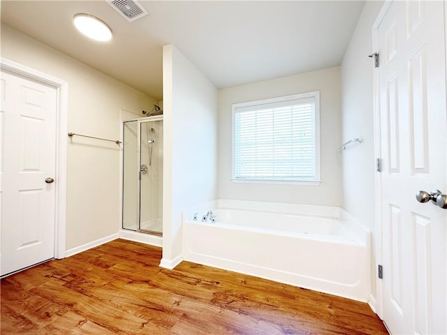 bathroom with hardwood / wood-style flooring and independent shower and bath