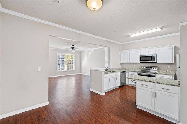 kitchen with a peninsula, a sink, stainless steel appliances, dark wood-type flooring, and white cabinetry