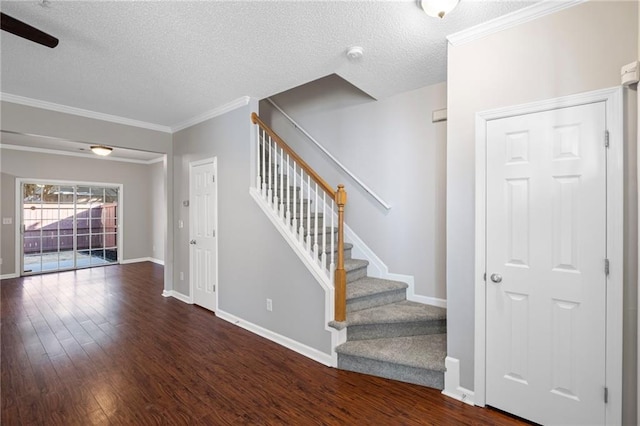 interior space with stairway, baseboards, a textured ceiling, and wood finished floors