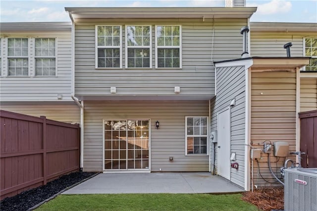 rear view of property featuring cooling unit, a fenced backyard, a chimney, and a patio area