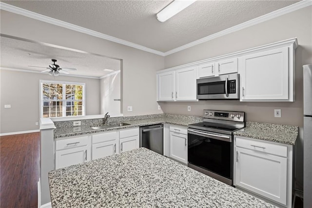 kitchen featuring white cabinetry, a peninsula, stainless steel appliances, and a sink