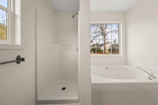 bathroom with a stall shower and a bath